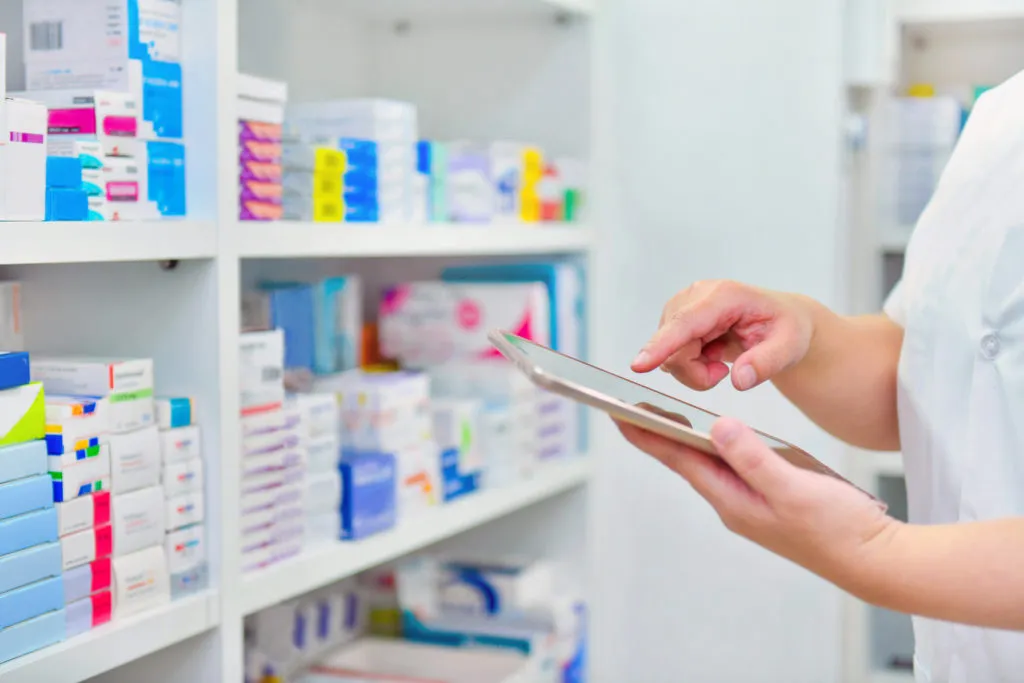 Pharmacist holding computer tablet in pharmacy drugstore